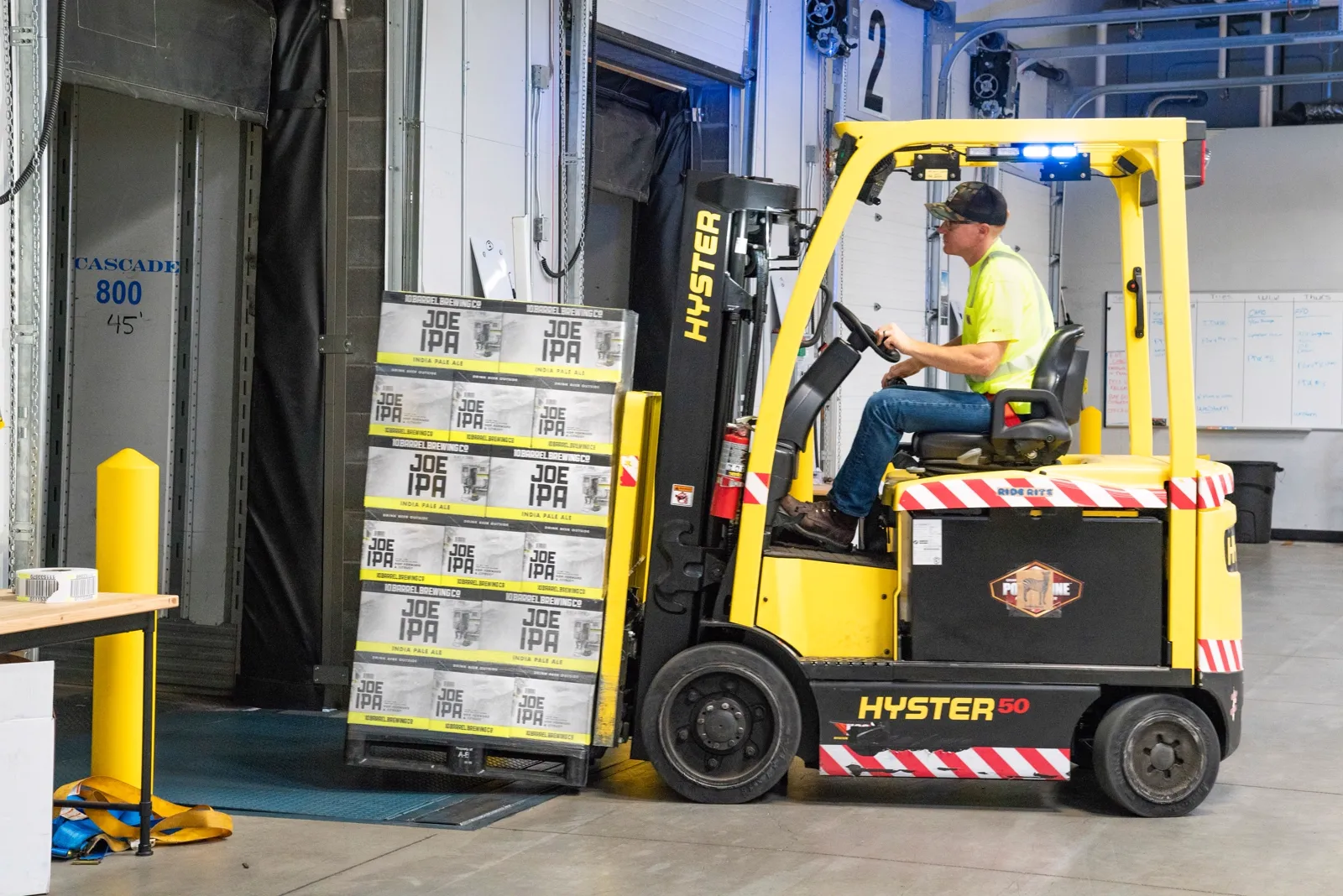 Used Hyster 50 forklift loading pallets at a warehouse dock, for sale in the Richmond metro